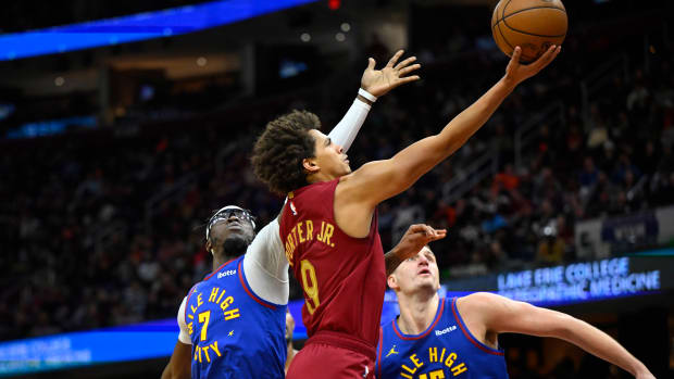 Nov 19, 2023; Cleveland, Ohio, USA; Cleveland Cavaliers guard Craig Porter (9) drives against Denver Nuggets guard Reggie Jackson (7) and center Nikola Jokic (15) in the fourth quarter at Rocket Mortgage FieldHouse.